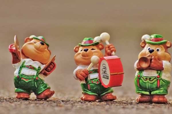 imagen de tres esculturitas de osos alegres caracterizados como músicos suizos